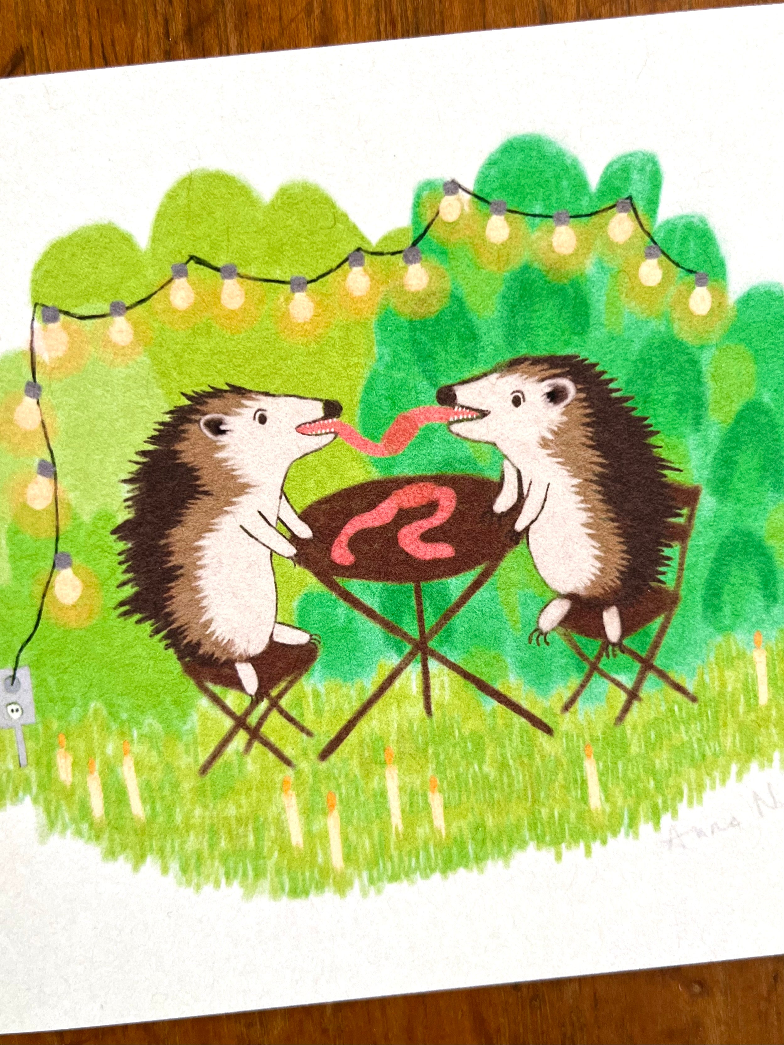 Fine art print van een tekening van twee egels die aan het picknicken zijn en samen een worm eten. Getekend door Anne Neuteboom cabaretier Anne Neut Boetiek.