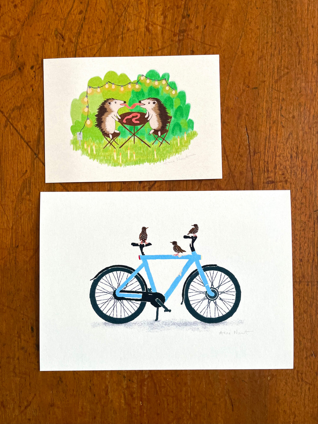 Fine art print van een tekening van twee egels die aan het picknicken zijn en samen een worm eten. Getekend door Anne Neuteboom cabaretier Anne Neut Boetiek.