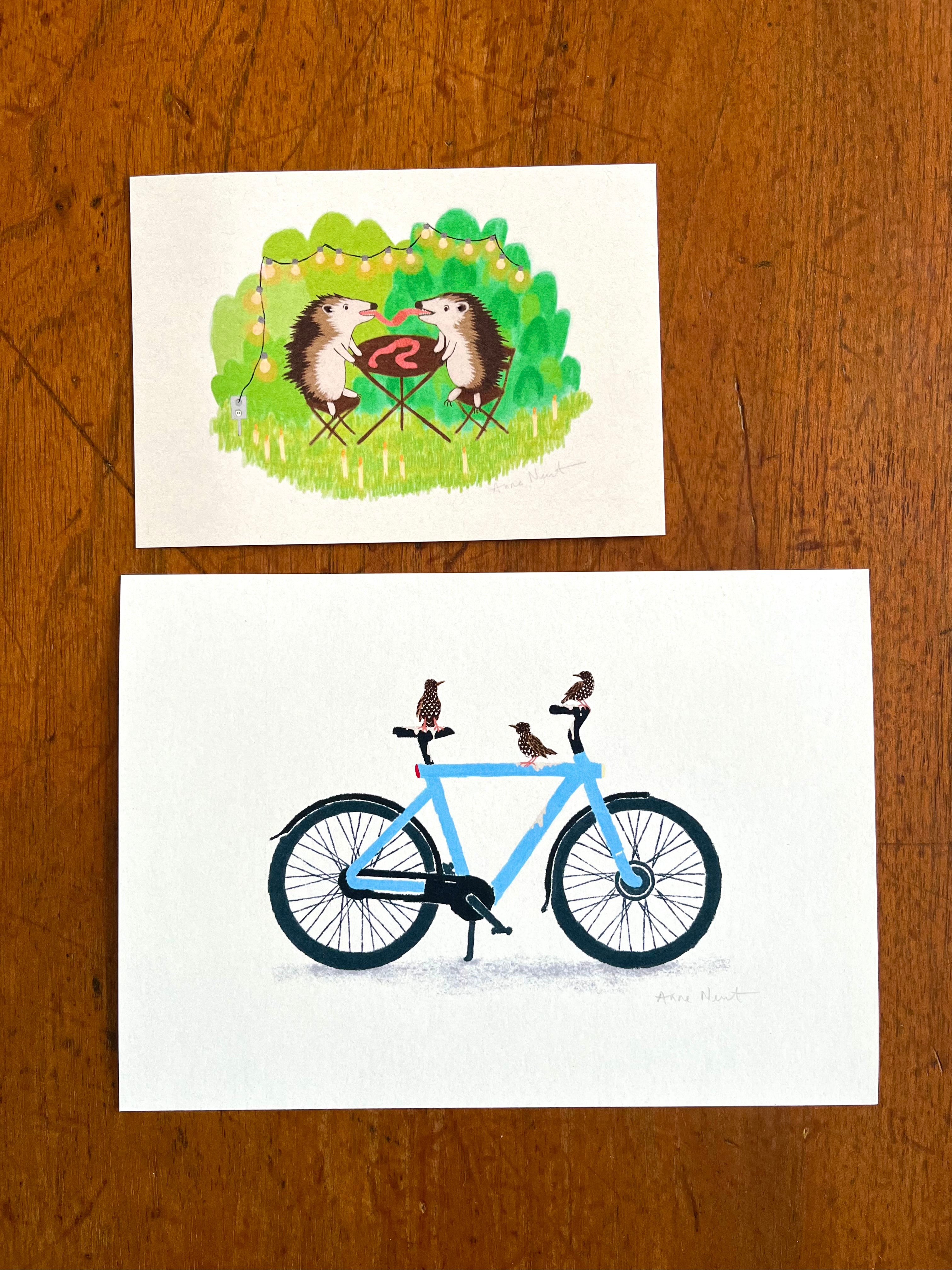 Fine art print van een tekening van twee egels die aan het picknicken zijn en samen een worm eten. Getekend door Anne Neuteboom cabaretier Anne Neut Boetiek.