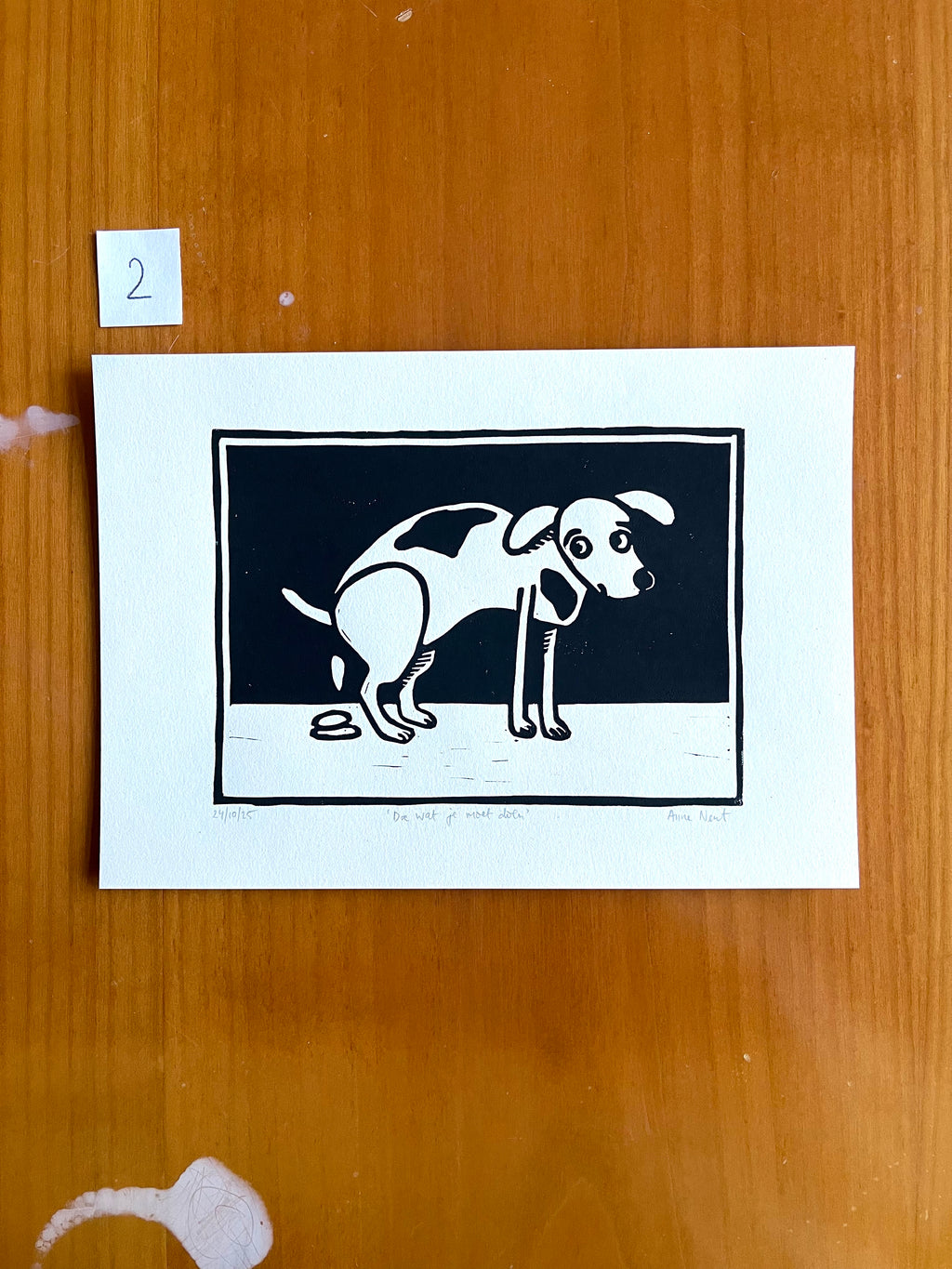 Linoprint door Anne Neuteboom cabaretier van hond die een drolletje doet Anne Neut Boetiek