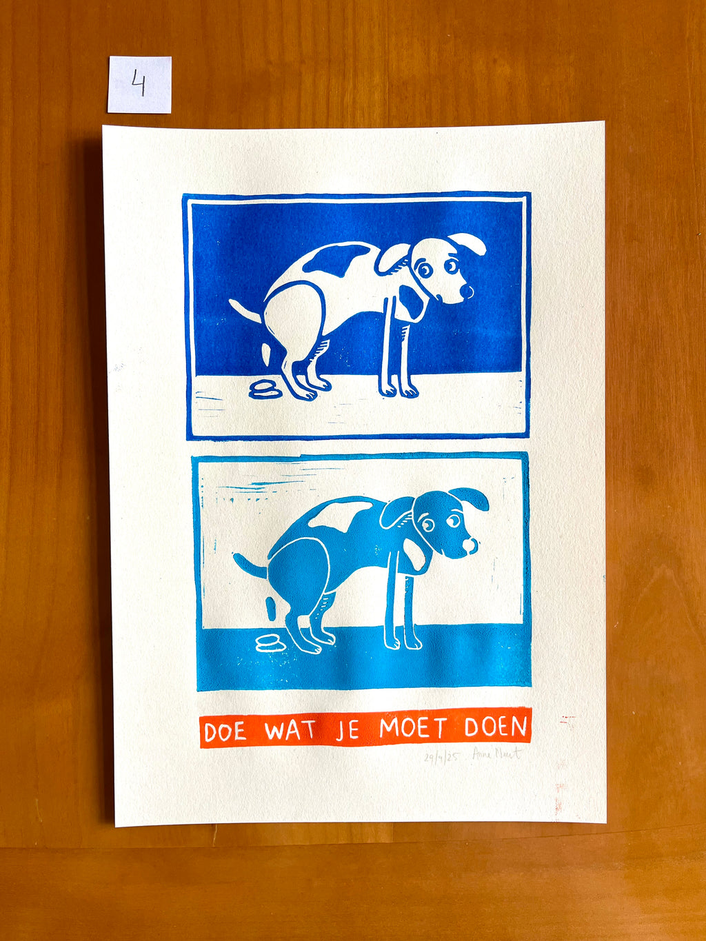 Linoprint van tekening van poepende hond door Anne Neuteboom cabaretier Anne Neut Boetiek